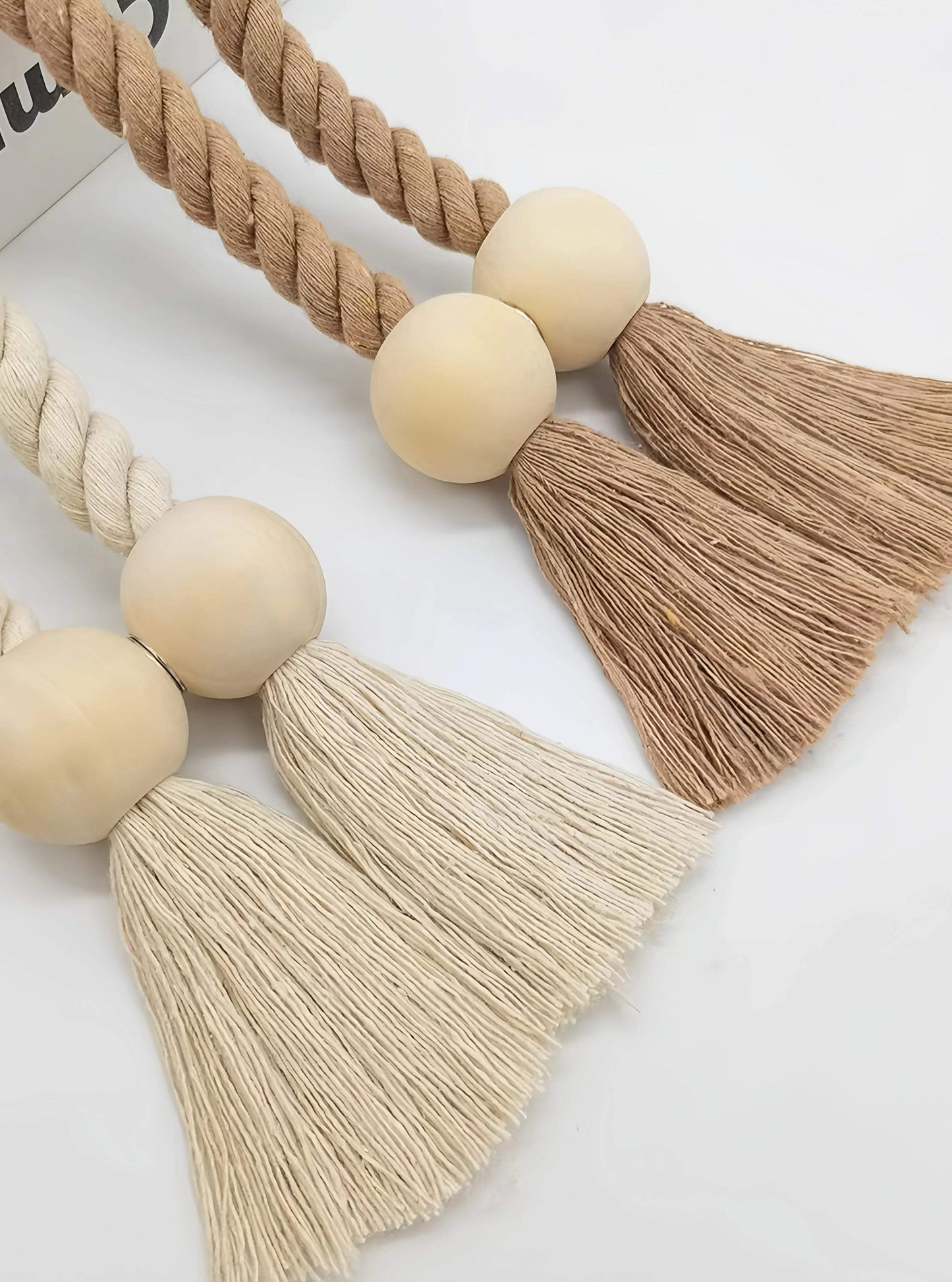 "pompons en laine tassels rideau blanc avec plante de fond, qualité chaleureuse"