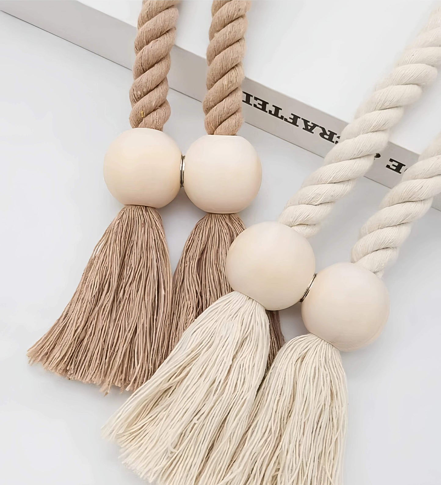 Rideau blanc avec frange en laine. (a white curtain with yarn fringe.)