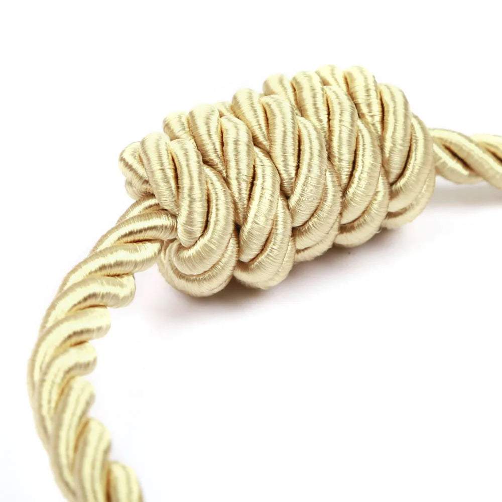 "bracelet torsadé ornemental en or" (twisted rope decorative bracelet in gold) would be a suitable keyword for this image. it highlights the unique twist design and the fact that it's made of gold, while also implying that it's a decorative piece.