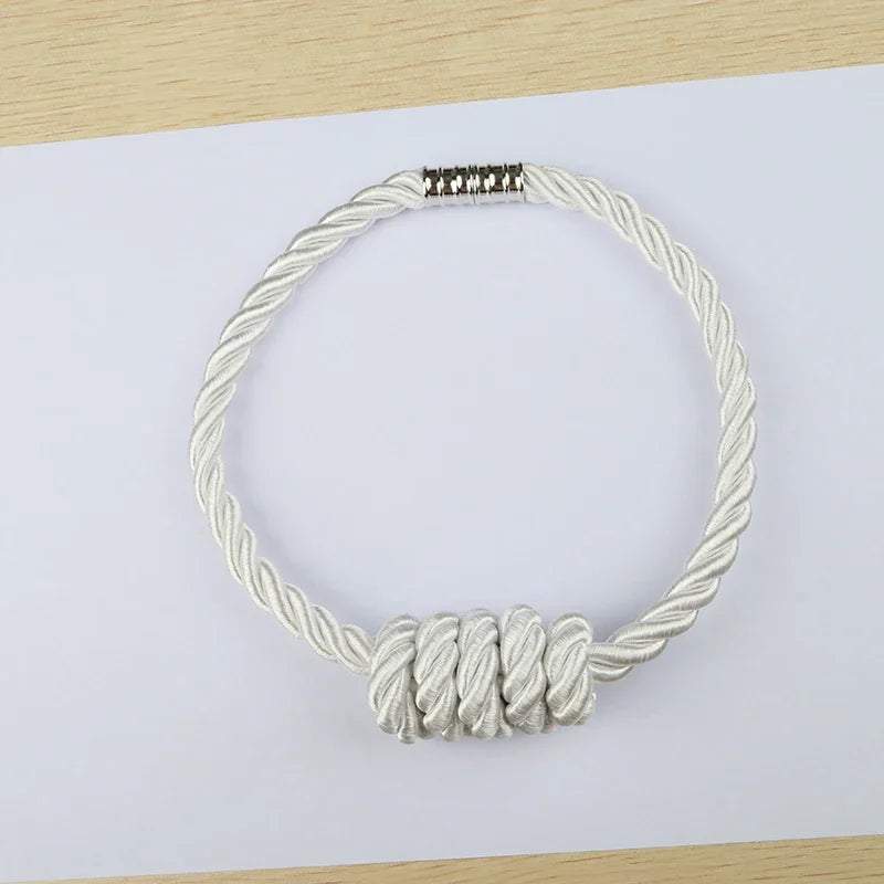 "collier en corde blanche avec fermoir argenté" (necklace made of white rope with silver clasp).