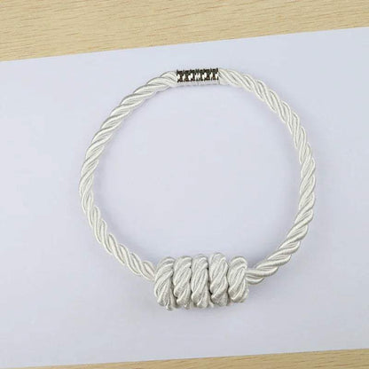 "collier en corde blanche avec fermoir argenté" (necklace made of white rope with silver clasp).