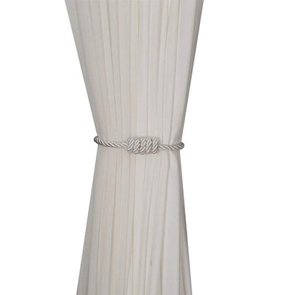 "collier en corde blanche avec fermoir argenté" (necklace with white rope and silver clasp). this keyword highlights the two main features of the image: the white rope and the silver clasp.