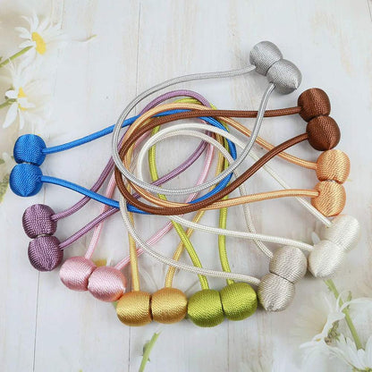 "deux boules blanches avec cordes décoratives" (two white balls with decorative ropes) could be a simple keyword for this image. it highlights the main elements of the picture while being concise and easy to understand.